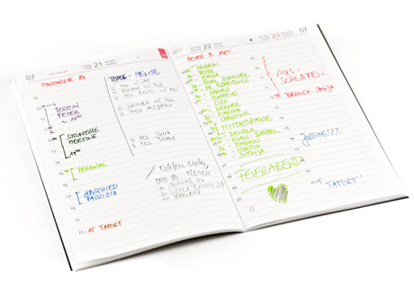 Aufgeschlagenes Heft eines X17-Tagesplaners mit farbenfrohen, strukturierten handschriftlichen Einträgen.