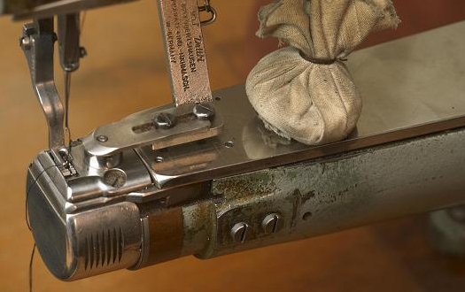 Detailaufnahme einer professionellen Industrie-Nähmaschine für die Herstellung von Leder-Notizbüchern und Terminkalendern in einer Manufaktur.